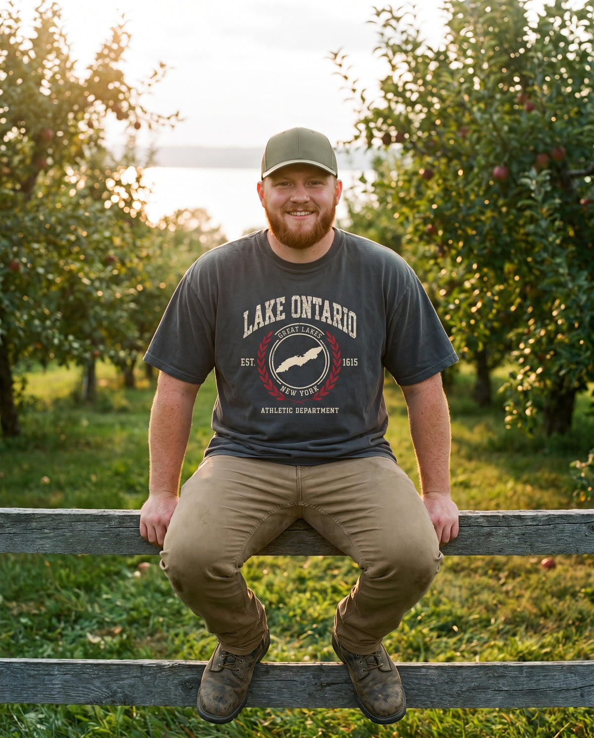 Lake Ontario Athletic Department tee in Coal, on an orchard fence in Williamson