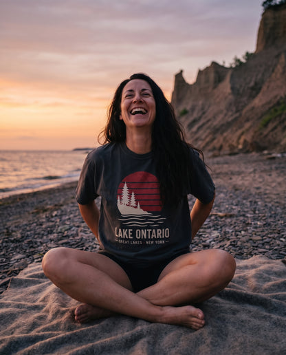 Lake Ontario Sunset tee in Black, worn on the beach at Chimney Bluffs