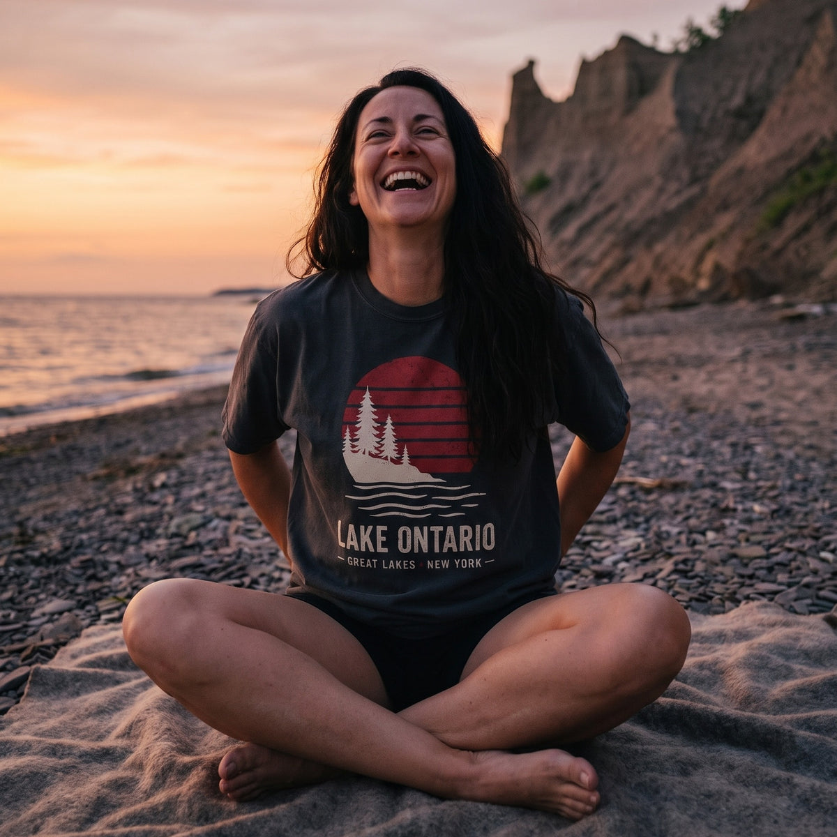 Lake Ontario Sunset tee in Black, worn on the beach at Chimney Bluffs