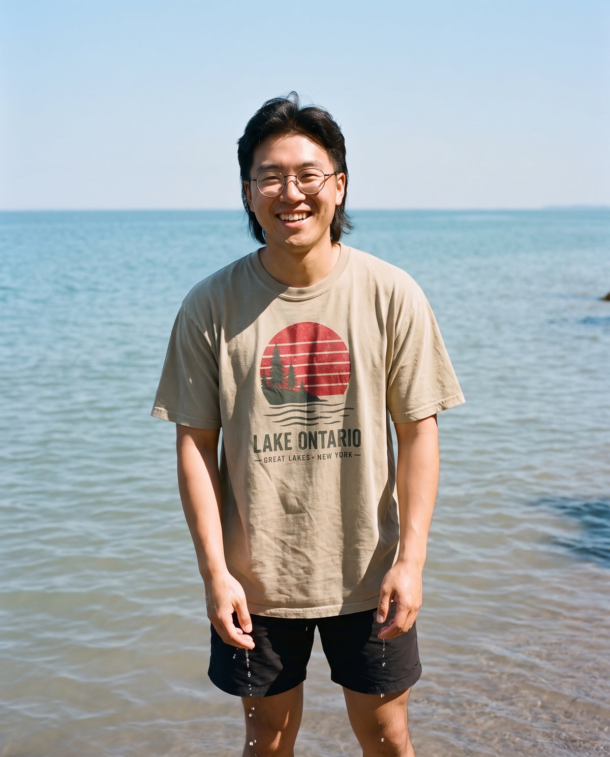 Sunset Tee in Khaki, worn on the shore of Lake Ontario